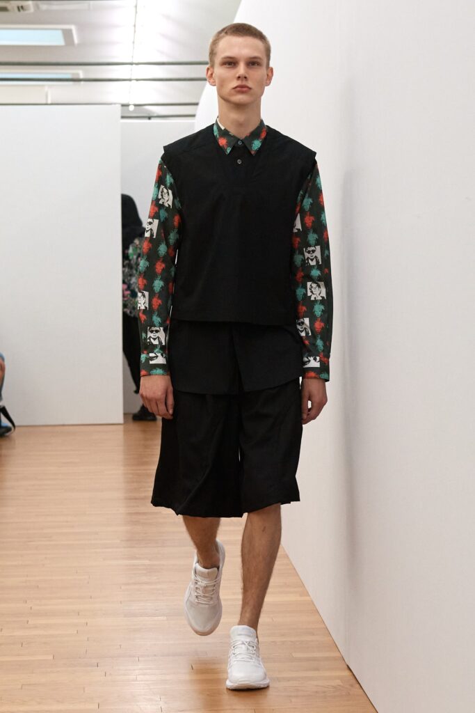 A relaxed black top with a collared neckline and printed short pants.