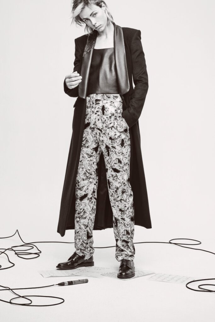 A fitted black coat paired with printed pants, showcasing a stylish and modern look.