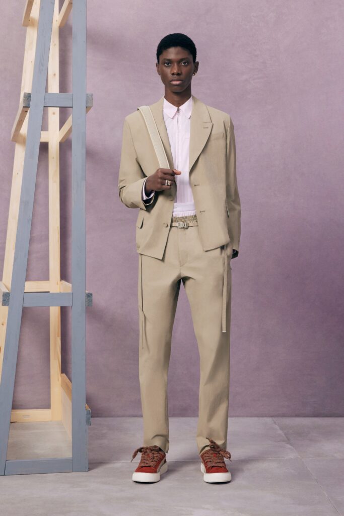 A tailored beige suit paired with a long-sleeve pink shirt, exuding modern elegance.