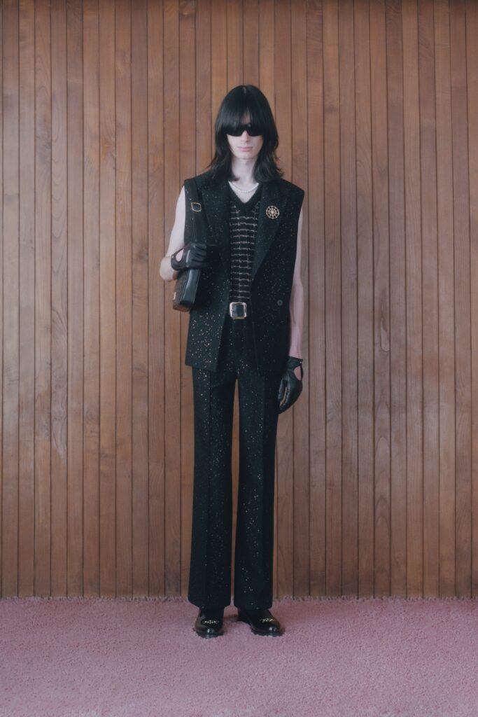 A fitted black sleeveless vest paired with embroidered pants for a stylish look.