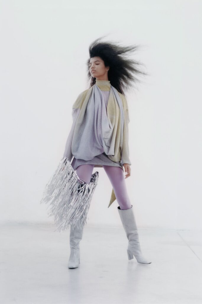 A relaxed gray and purple long-sleeve top paired with fitted pants, showcasing a layered design.