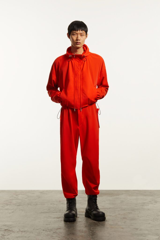 A relaxed red jacket with a hood paired with matching pants, featuring a zippered detail.