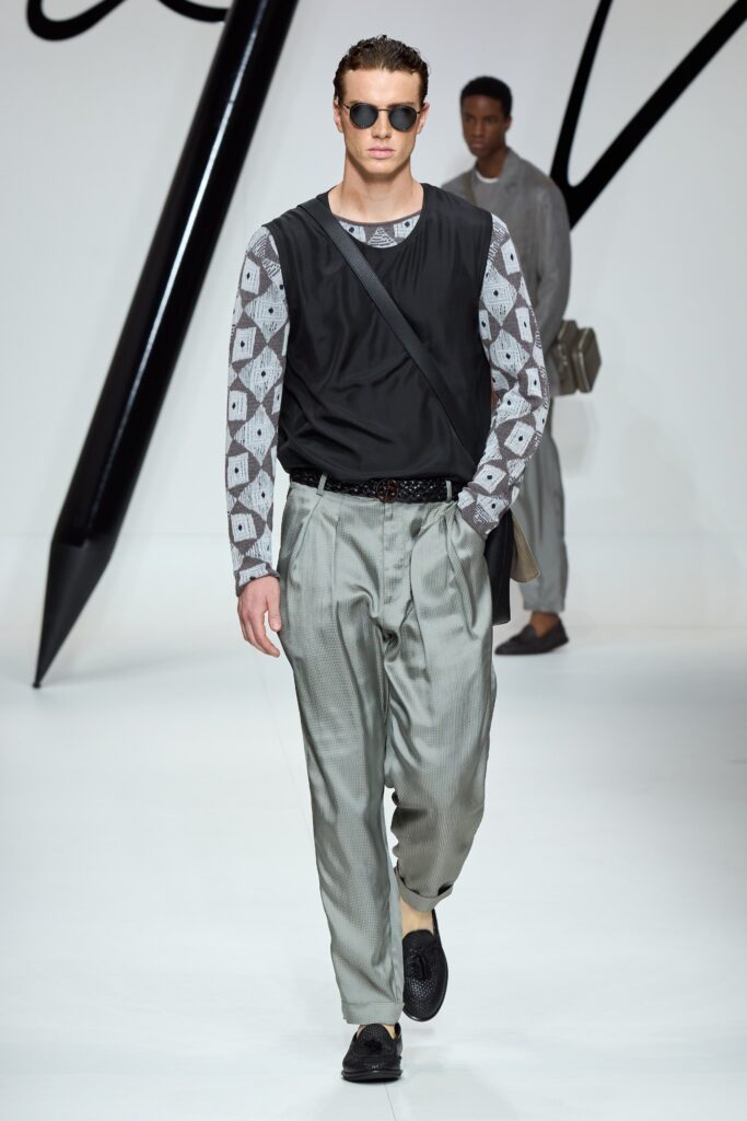 A relaxed black long-sleeve shirt paired with gray striped pants.