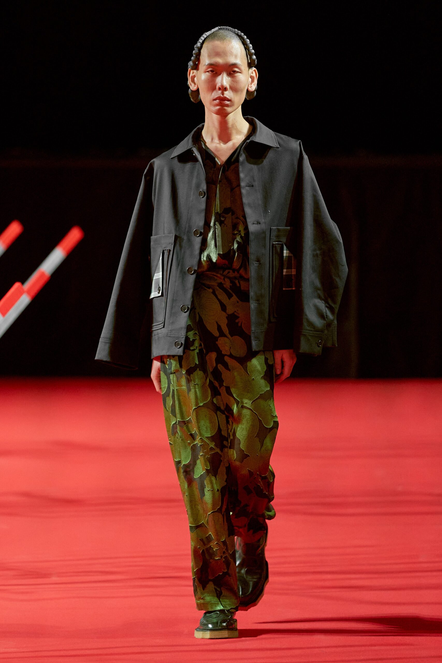A relaxed black jacket paired with green printed pants, featuring a collared design.