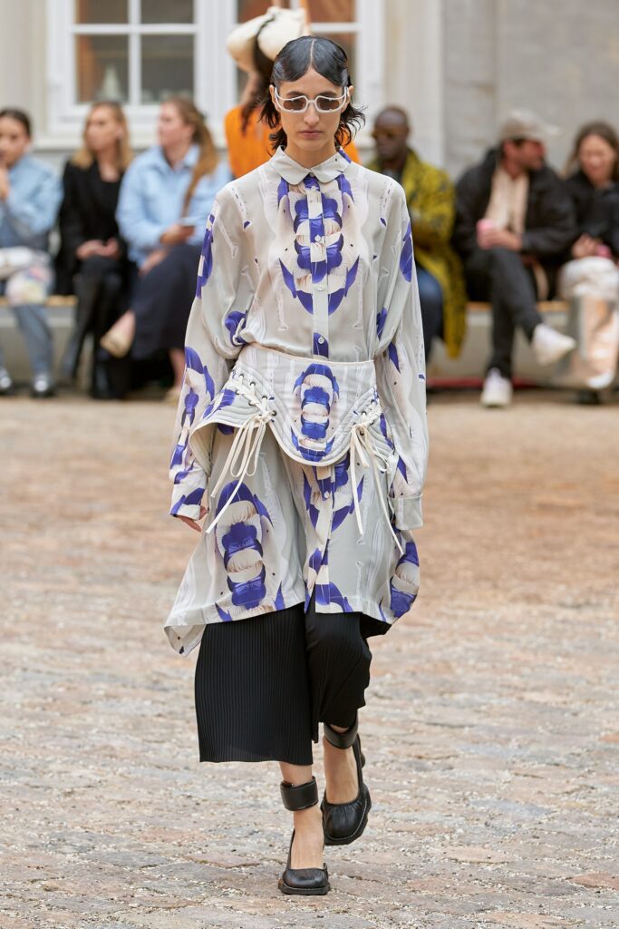 A relaxed white and blue printed dress with long sleeves and a collared neckline.