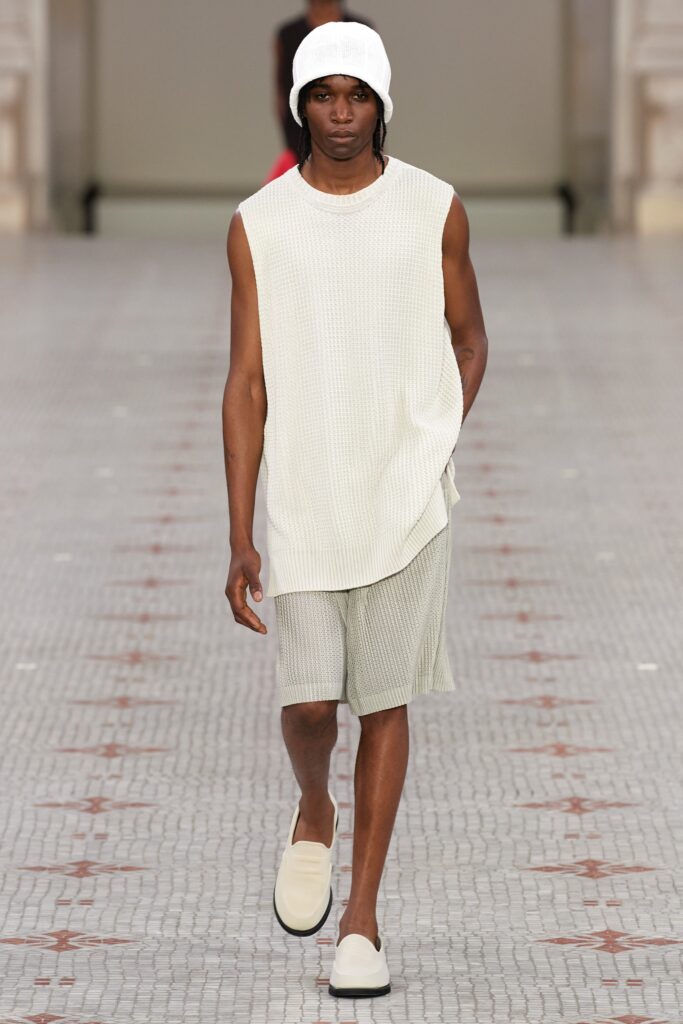 A relaxed white cotton sleeveless top paired with gray shorts, featuring a layered design.