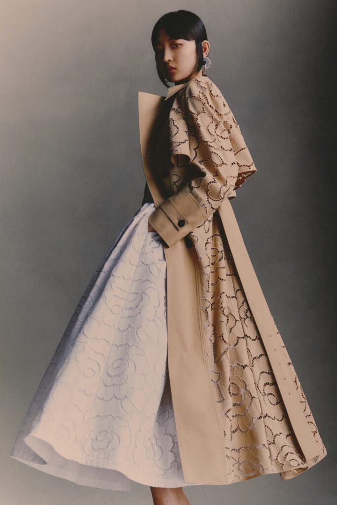 A fitted beige embroidered coat layered over a white A-line dress.