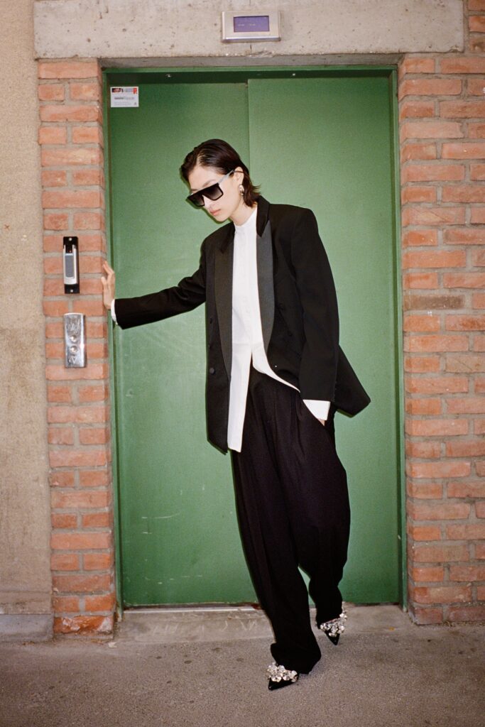 A relaxed black blazer with long sleeves paired with straight-leg black pants.