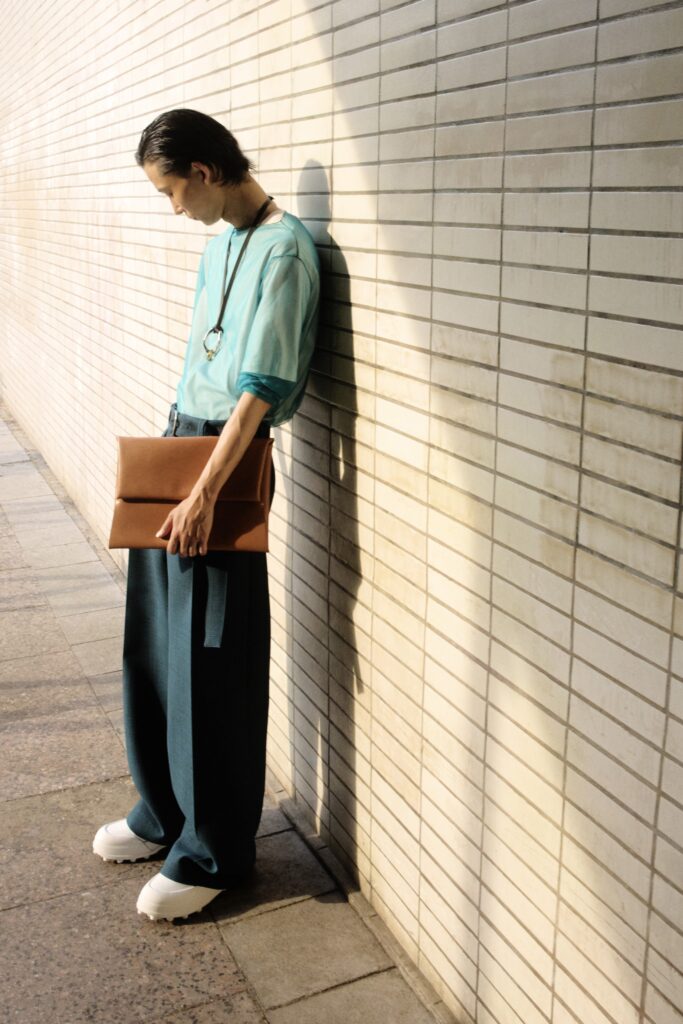 An oversized blue and green long-sleeve shirt paired with wide-leg pants for a relaxed look.