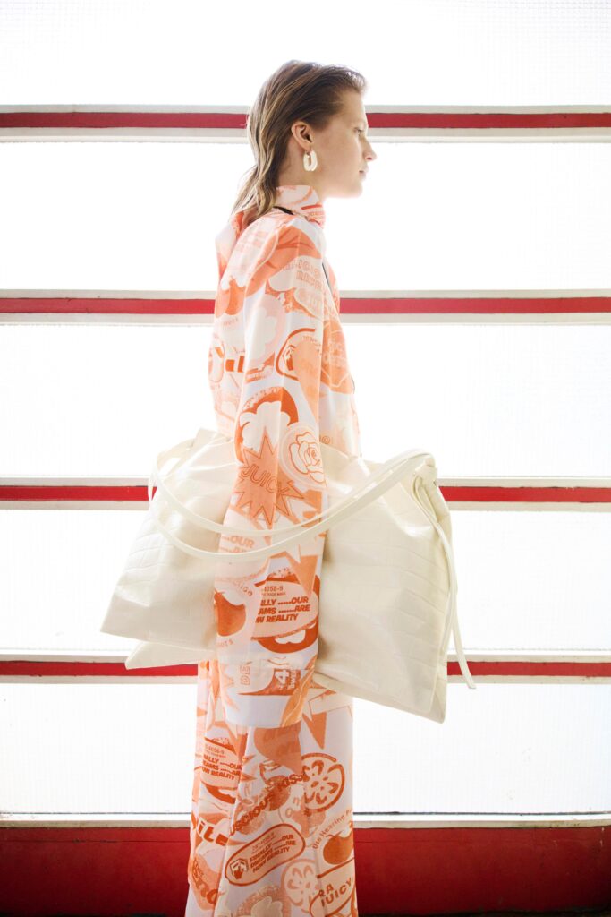 A relaxed orange dress with long sleeves, a collared neckline, and a printed design.