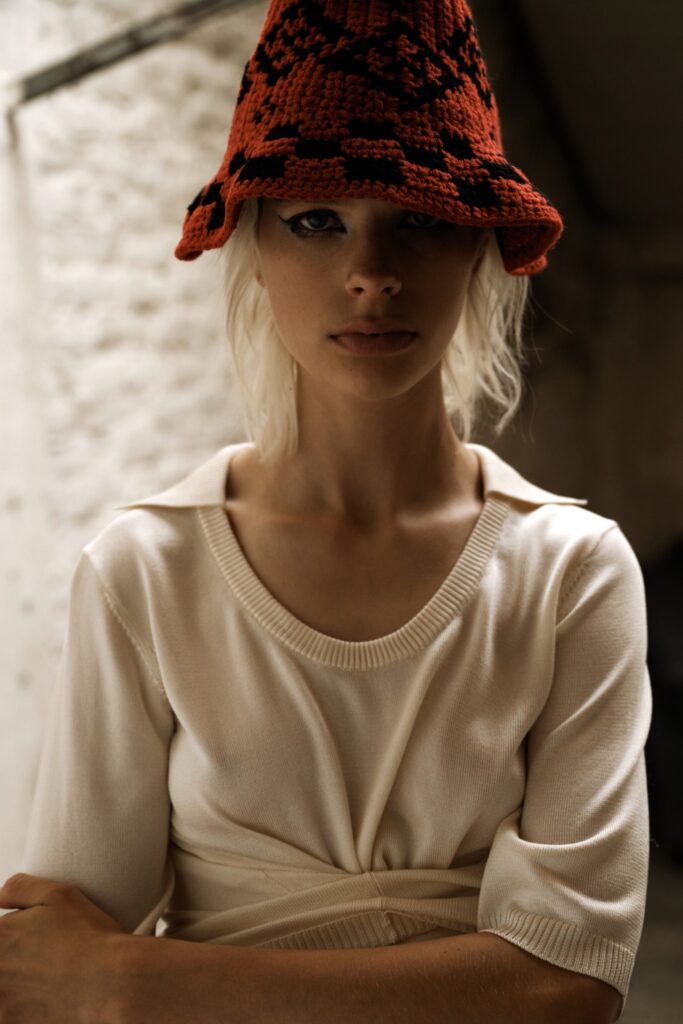 A fitted cream top with short sleeves and a V-neckline featuring a wrapped design.