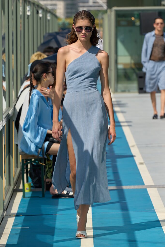 A fitted blue cotton sleeveless dress with a V-neckline and a high slit.