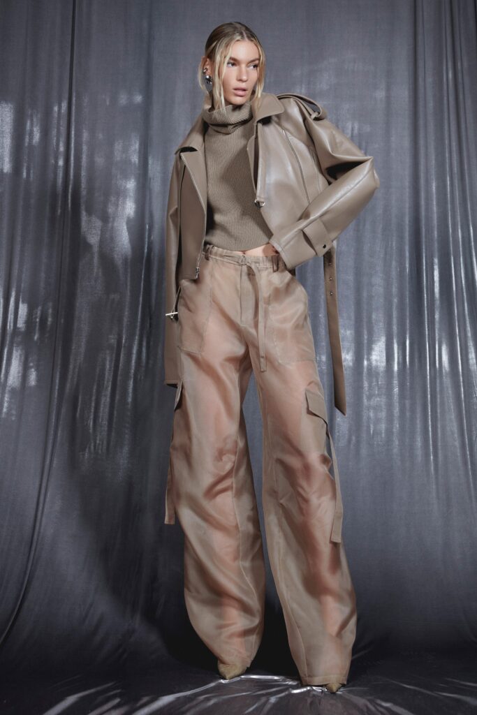 A relaxed beige leather jacket paired with cotton pants featuring an asymmetric design.