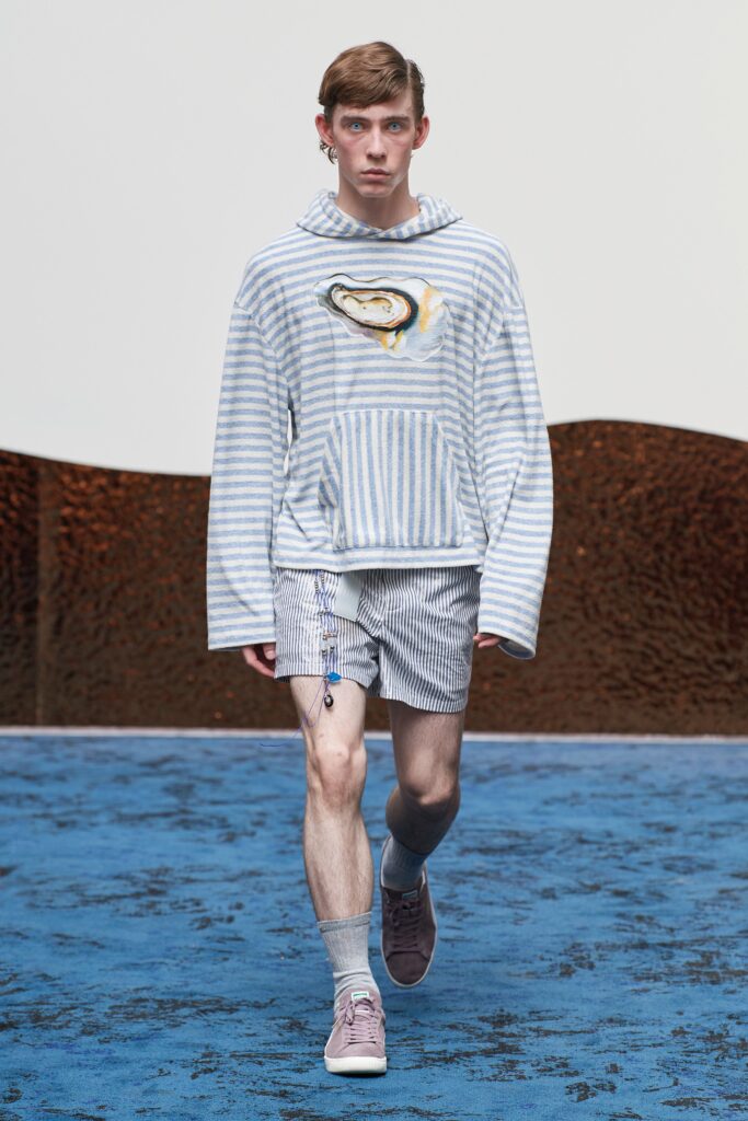 A relaxed blue and white striped hoodie paired with matching shorts for a casual look.