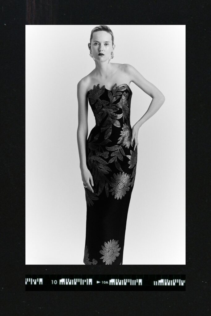 A fitted black silk strapless gown featuring intricate embroidery.