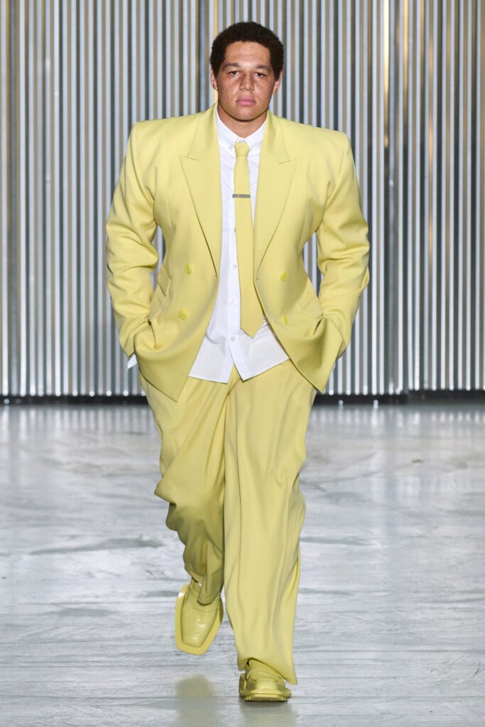 A relaxed yellow cotton suit with long sleeves and a collared shirt, featuring buttoned details.