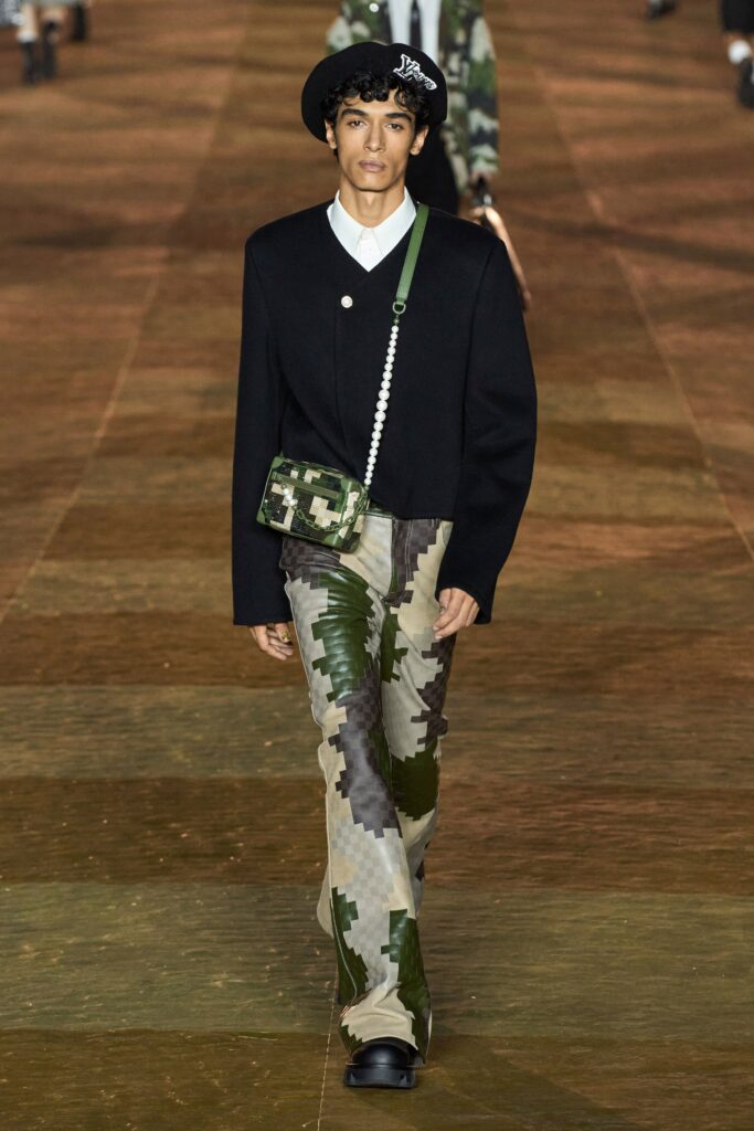 A relaxed black jacket with long sleeves paired with camouflage pants featuring a buttoned design.