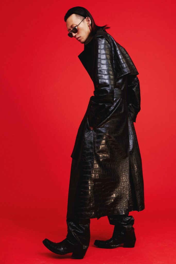 A fitted black leather coat with a collared neckline and asymmetric design.