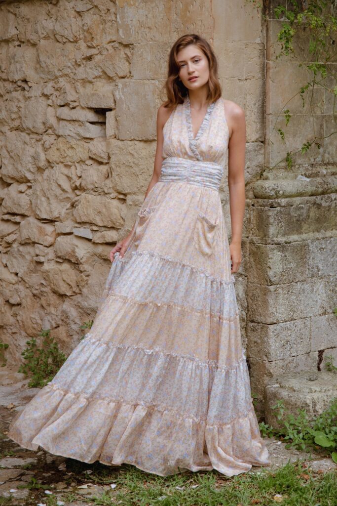 A relaxed beige and cream tiered maxi-dress with a sleeveless halter design.