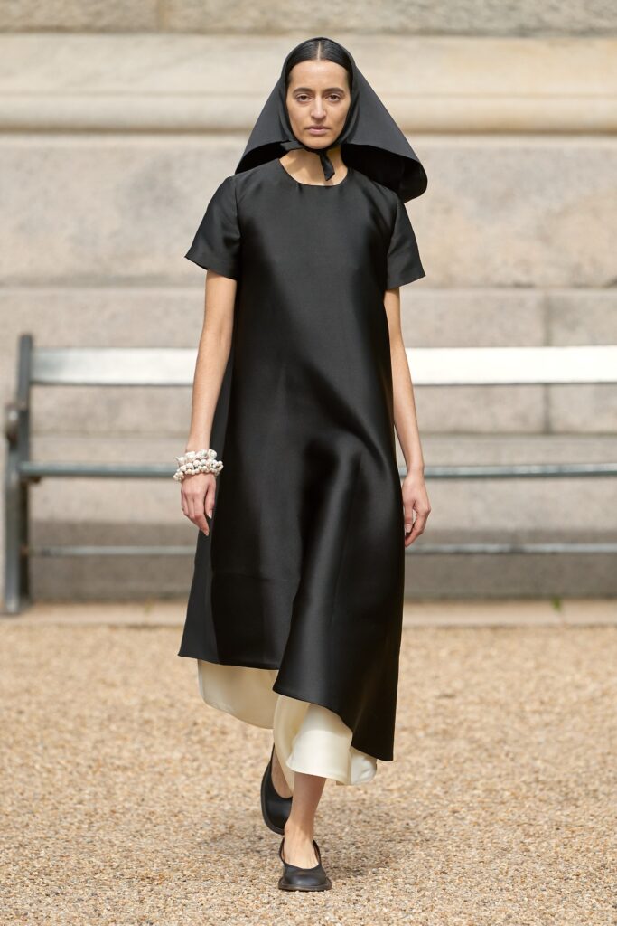 A relaxed black silk dress with short sleeves and an asymmetric hemline.
