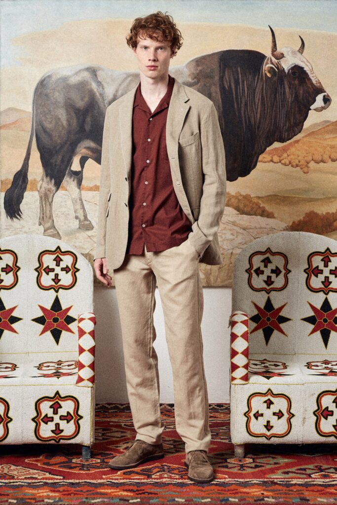 A tailored beige linen blazer with a collared shirt and straight-leg pants.