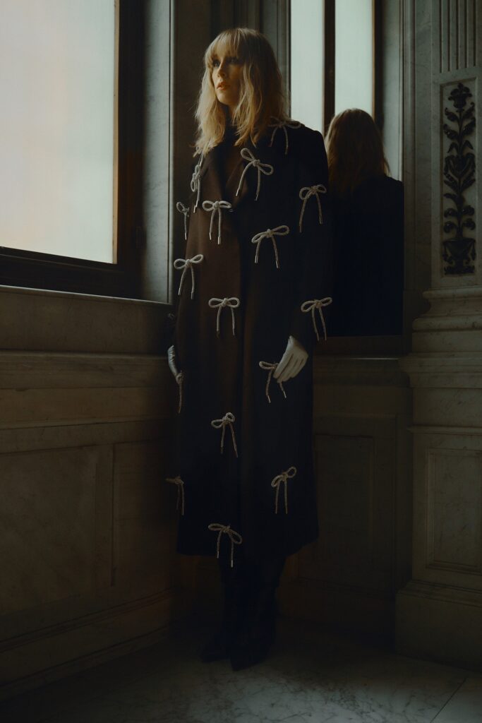 A relaxed black silk coat with long sleeves and embroidered details.