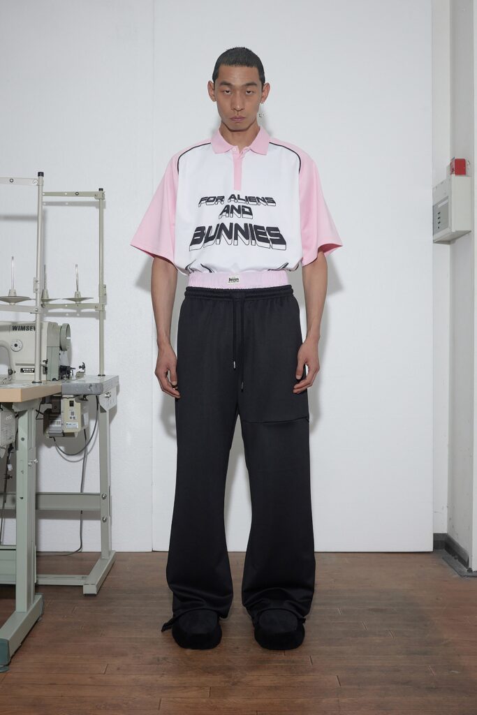 A relaxed-fit pink printed shirt with a collared neckline paired with black pants.