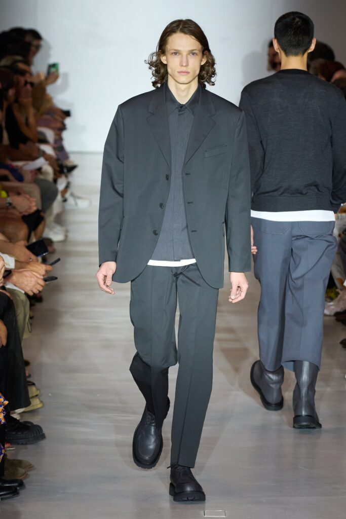 A tailored gray suit with a collared long-sleeve shirt and buttoned details.