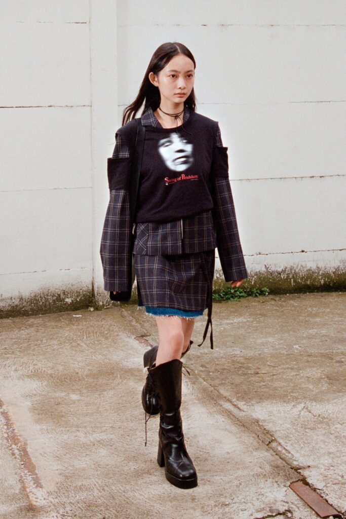A fitted black plaid top with long sleeves and a collared design, paired with a matching skirt.
