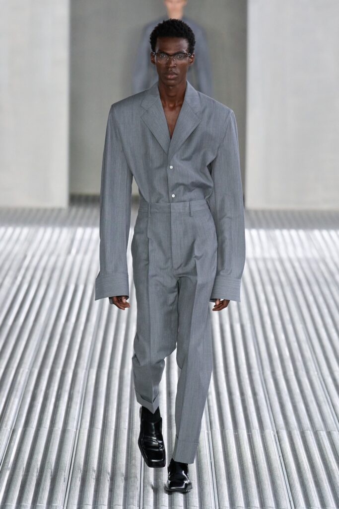 A tailored gray suit with long sleeves and a collared design, featuring buttoned details.