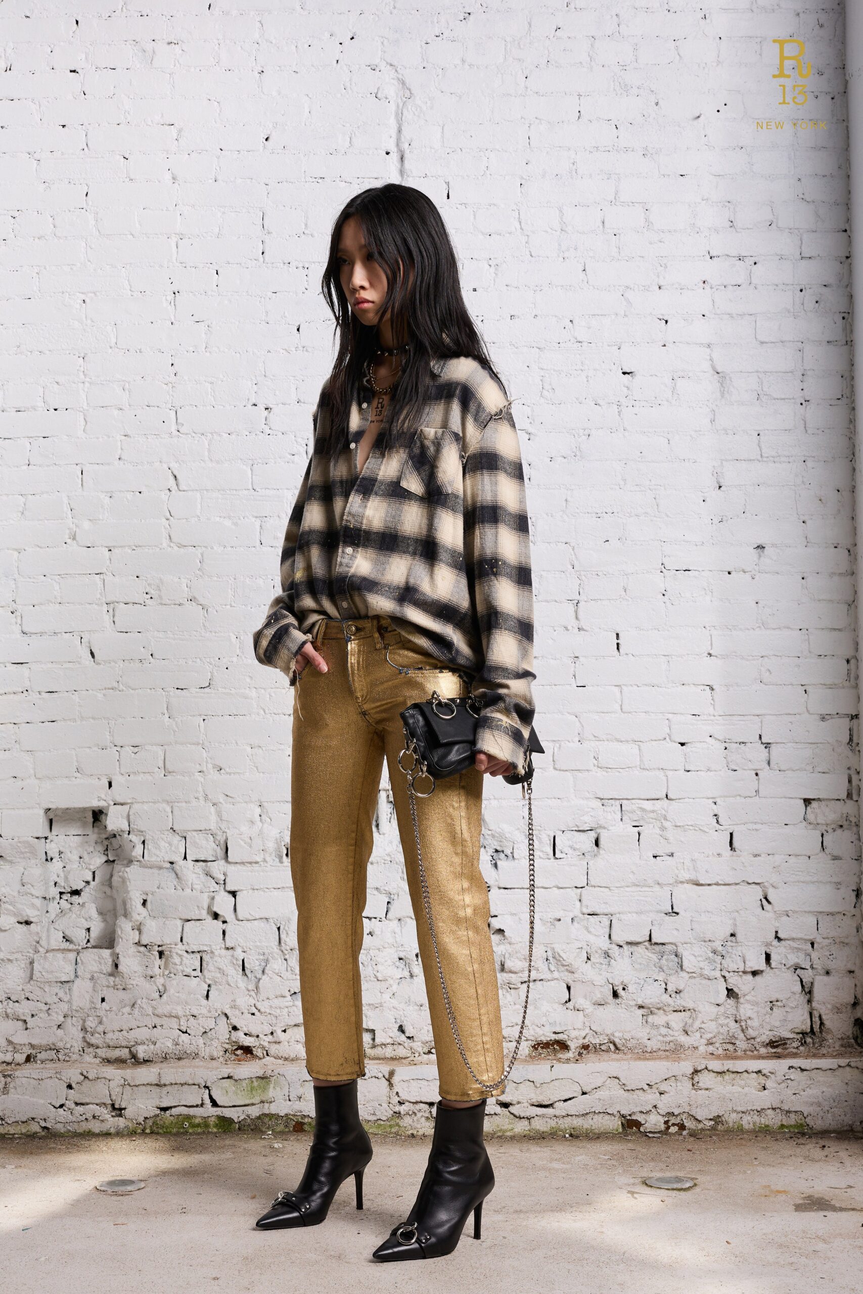 A fitted black checked shirt with long sleeves paired with slim gold pants.