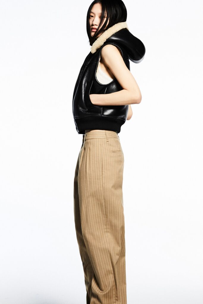 black leather vest and beige pants