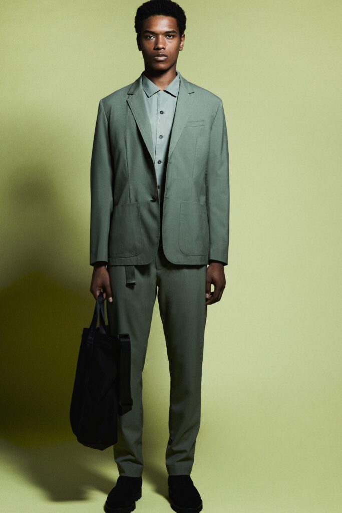 A tailored green cotton suit featuring a collared shirt and straight-leg trousers.