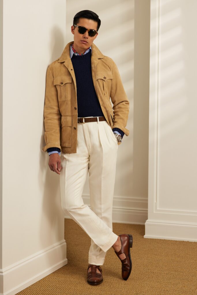 A tailored beige suede jacket with a collared neckline paired with straight-leg white pants.