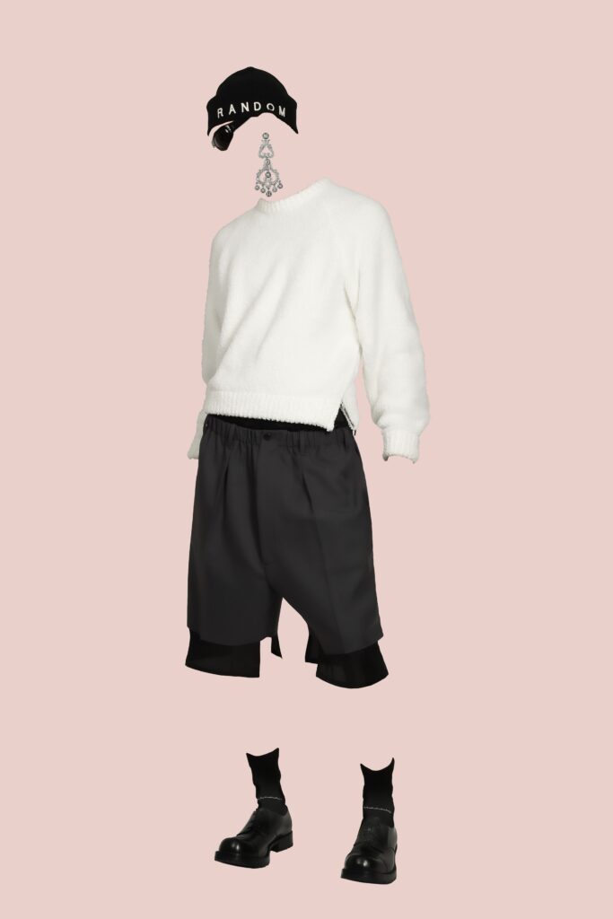A relaxed white long-sleeve sweater paired with black layered shorts.