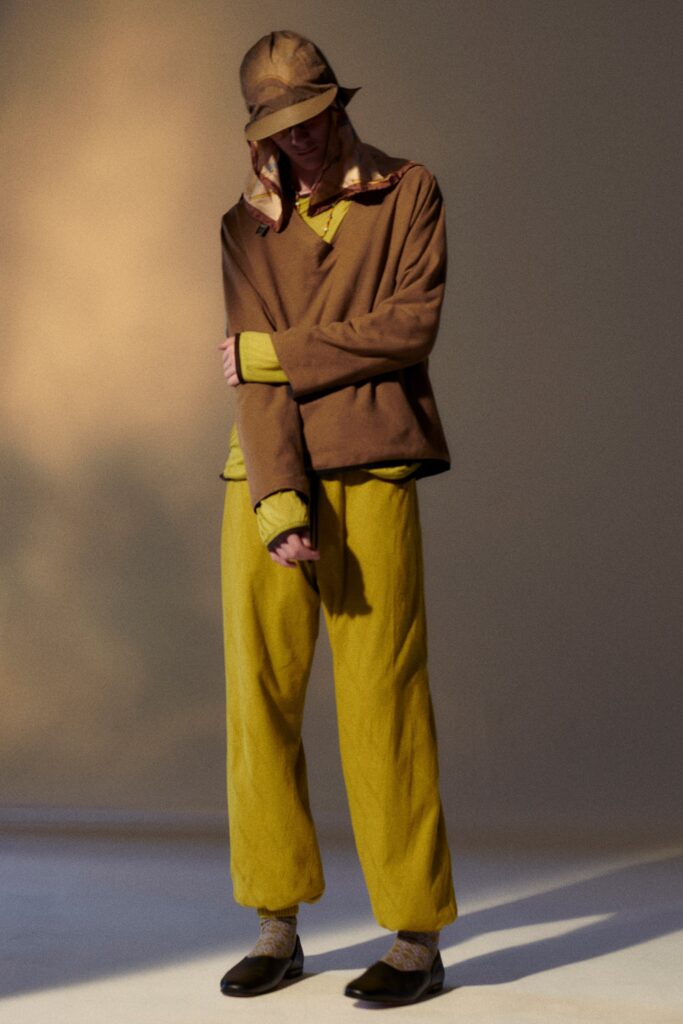 A relaxed brown top with long sleeves paired with yellow pants, featuring a layered design.
