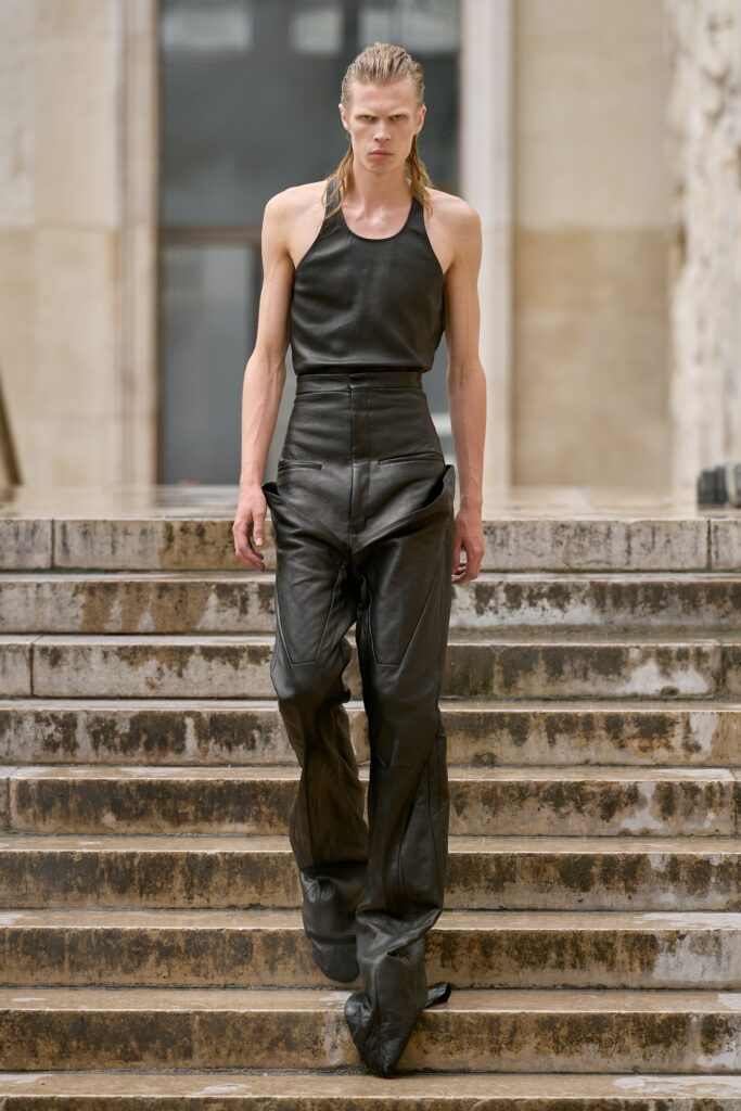 A fitted black leather sleeveless top paired with high-waisted straight-leg pants.