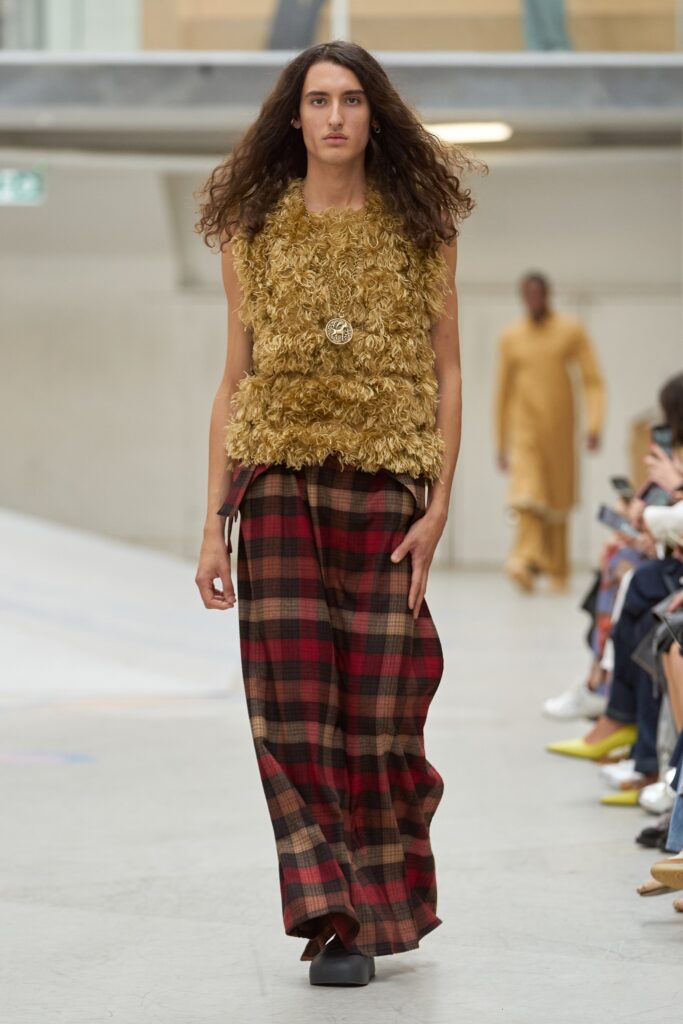 A relaxed brown wool sleeveless top paired with high-waisted plaid pants.