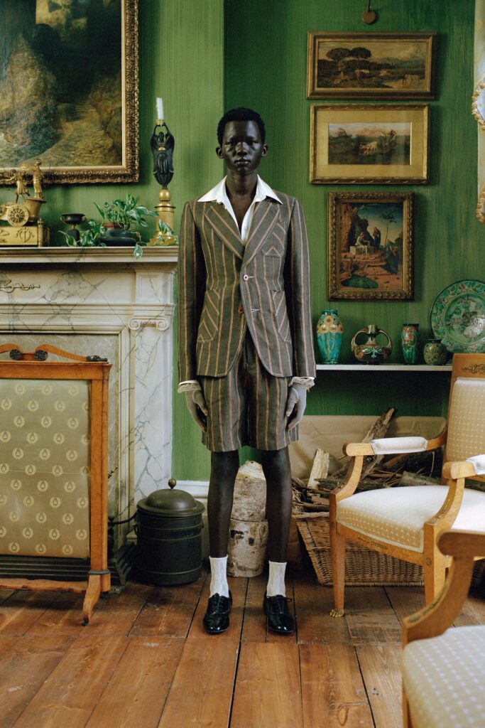 A tailored brown striped suit with a collared long-sleeve shirt.
