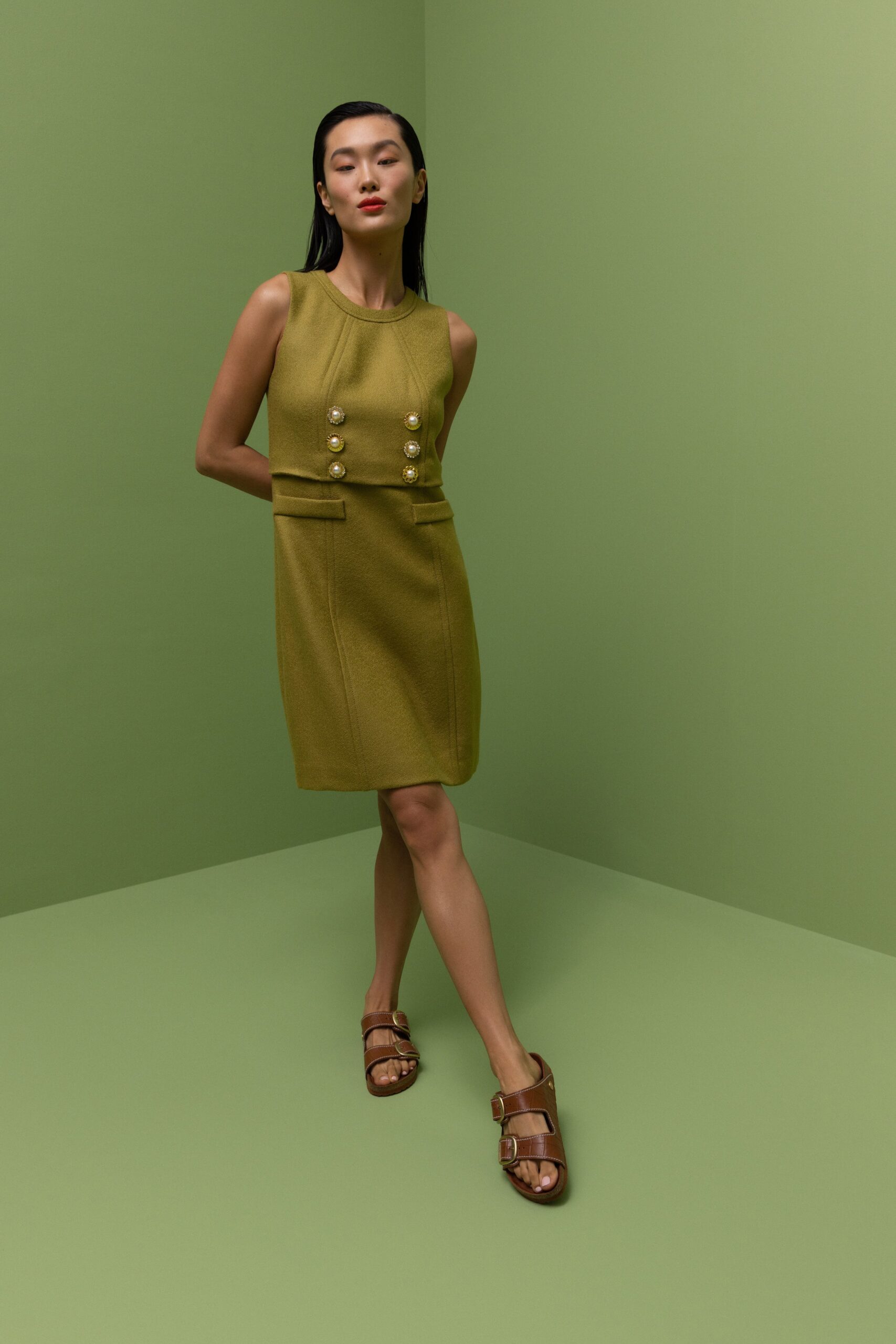 A fitted green cotton dress with a collared neckline and button details.