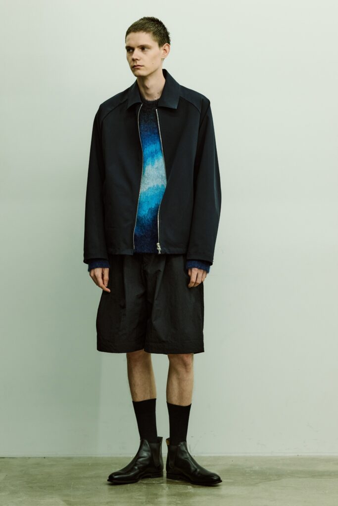 An oversized blue jacket paired with black shorts, creating a modern streetwear look.