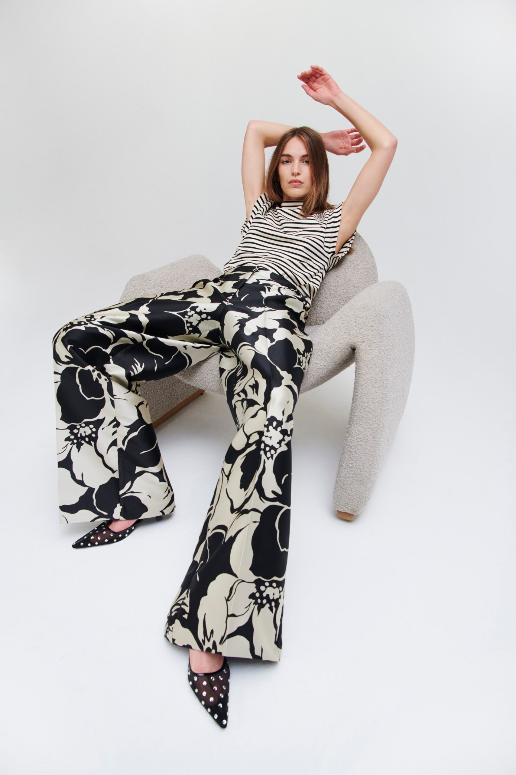 A fitted striped top paired with flared pants featuring a floral pattern in black and white.