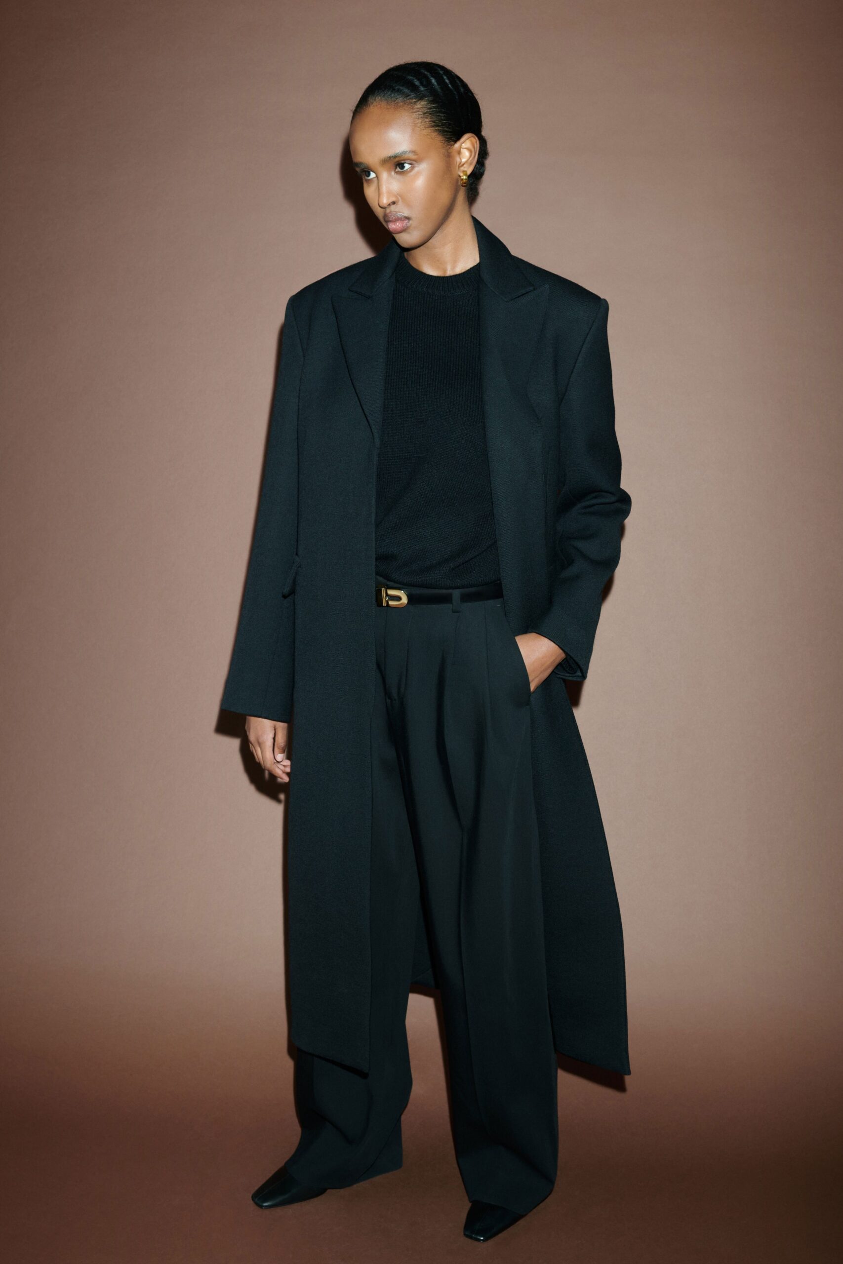 A relaxed black wool coat paired with straight-leg black pants for a sophisticated look.