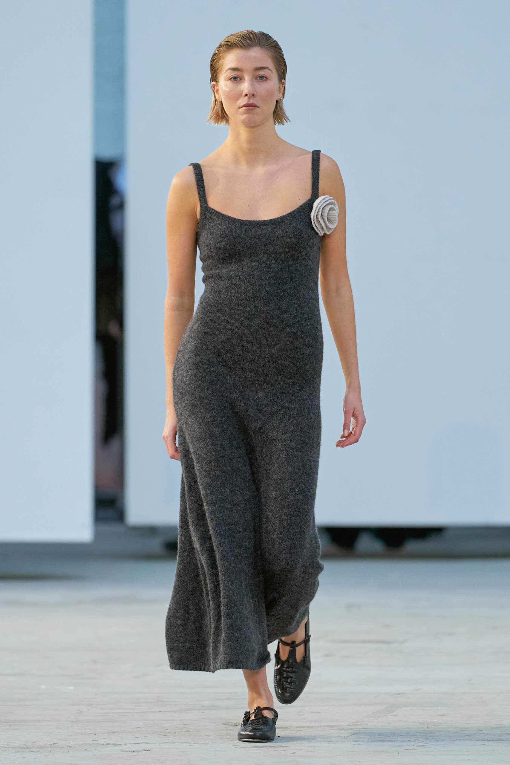 A fitted gray wool sleeveless dress with a V-neckline and straight-leg silhouette.