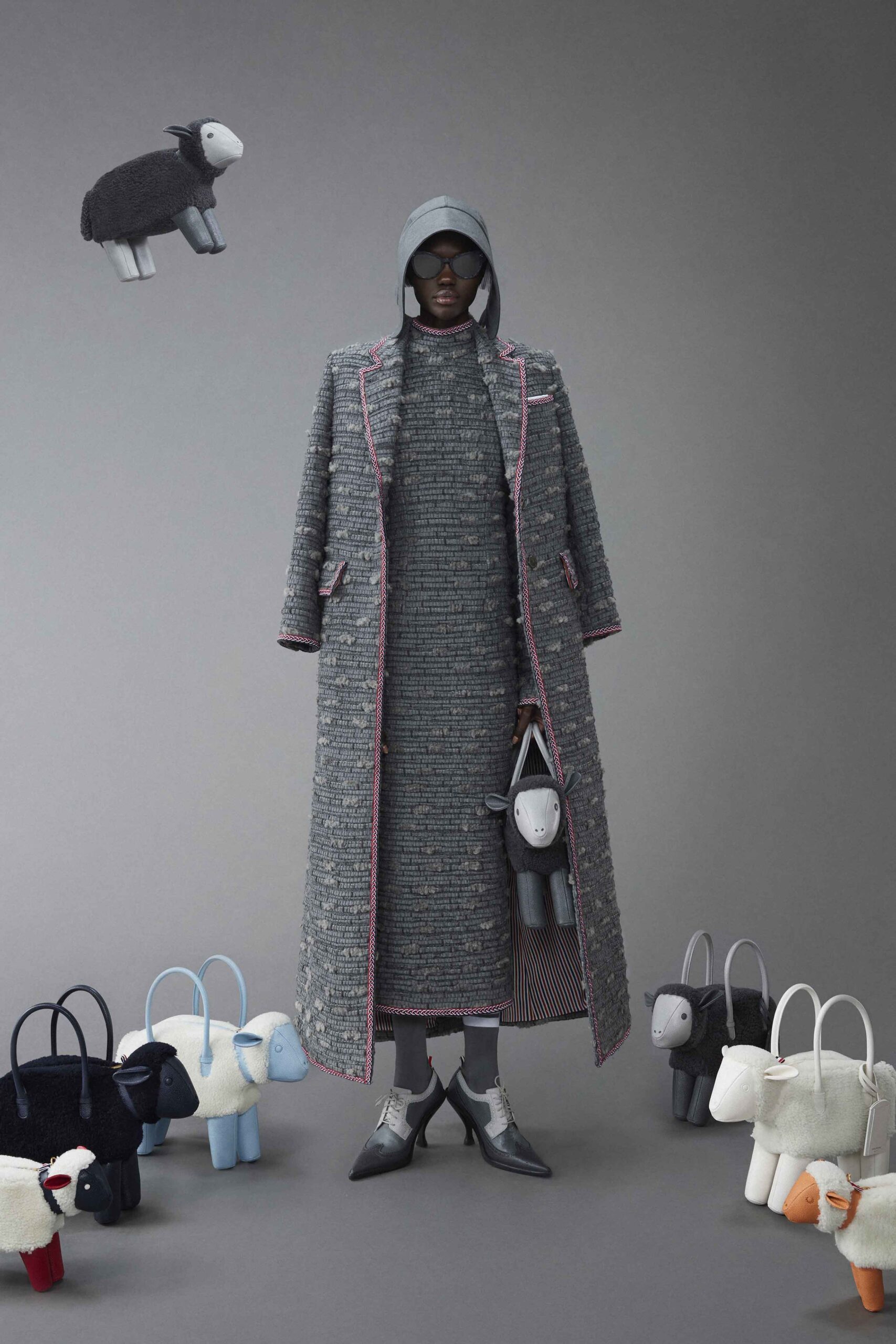 A fitted gray tweed coat dress with long sleeves and a hood, featuring a layered design.
