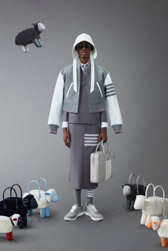 A relaxed gray jacket with long sleeves and a collared neckline paired with a high-waisted striped skirt.