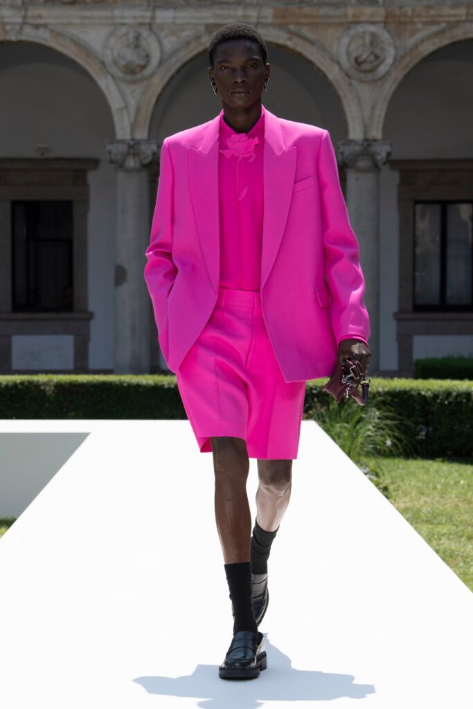 A fitted pink blazer paired with matching shorts, creating a bold summer look.