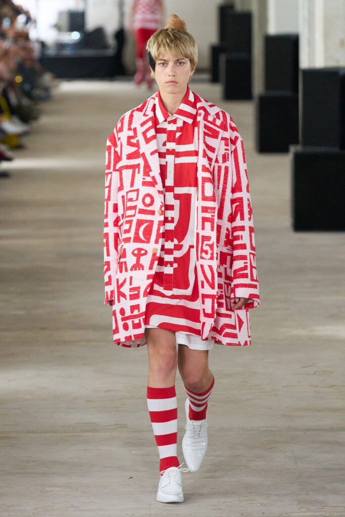 A relaxed red and white printed coat dress with a collared neckline and long sleeves.