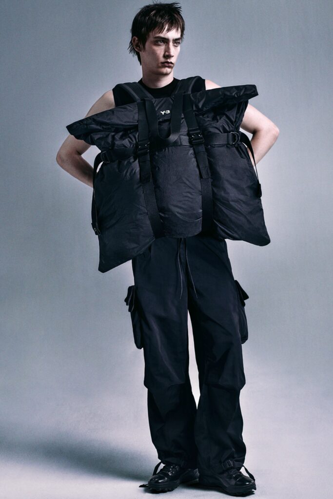 A relaxed black sleeveless jacket paired with matching pants featuring an asymmetric design.