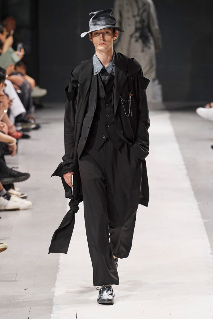 A relaxed black cotton suit featuring a long-sleeve collared shirt and layered design.